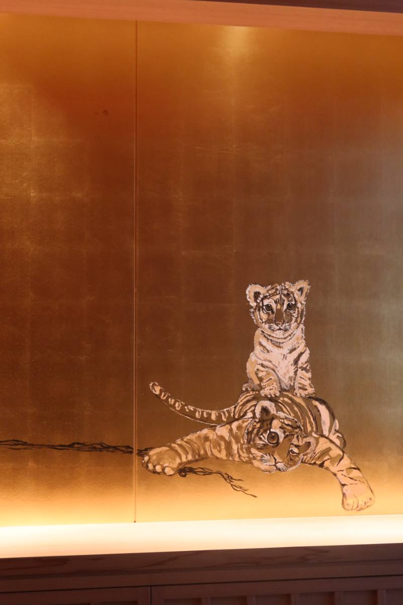 A tiger cub painted on a gold-leaf wall