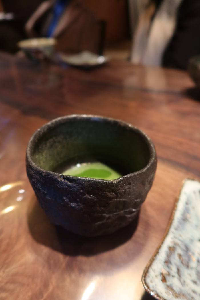 Matcha in a dark, rough-glazed bowl